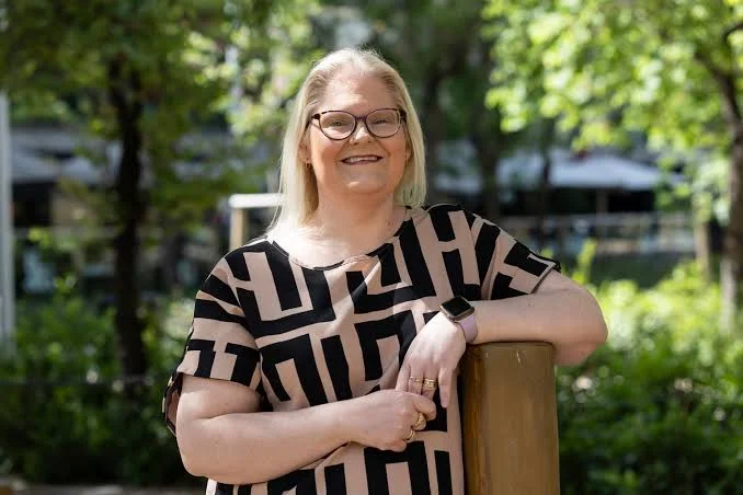 Louise Brown, la primera persona en el mundo nacida por fertilización asistida, sonriendo al aire libre durante su visita a la Argentina.